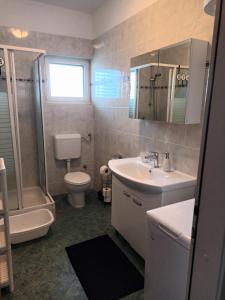普利莫顿Apartman Ita的一间带水槽、卫生间和淋浴的浴室