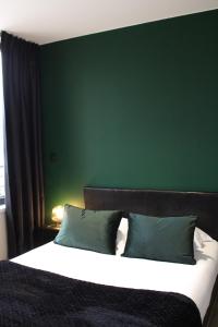 莫伯日Résidence "Le Vélodrome"的一间卧室设有一张大床和绿色的墙壁