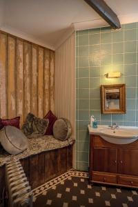 卡尔迪科特Medieval Manor的浴室配有盥洗盆、浴缸和盥洗盆