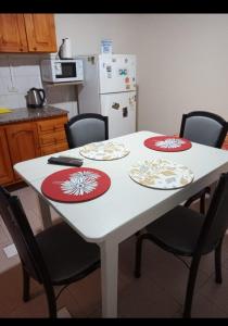 埃斯克尔Departamento Del Sol (Esquel-Chubut)的一张带四把椅子的白色桌子和白色冰箱
