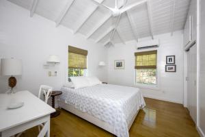 Gregory TownPalm Bluff cottage的白色卧室配有床和书桌