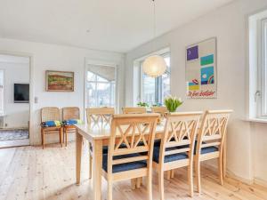 斯特兰比Holiday home Strandby XII的一间带木桌和椅子的用餐室
