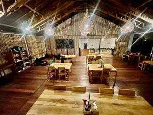 布纳肯3WILL Bunaken Dive Resort的餐厅设有木桌和椅子及灯