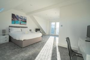 牛津Newly Refurbished Modern 4 Bed Detached House !的一间白色卧室,配有床和电视