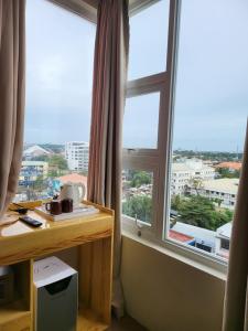 麦克坦Sempre Premier Inn - MACTAN AIRPORT HOTEL的客房设有2扇大窗户和1张带书桌的书桌。