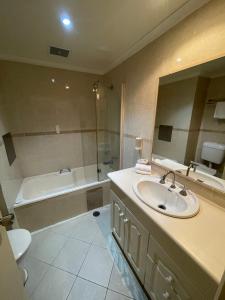 安特兰斯El Lago Waters Resort的一间带水槽、浴缸和卫生间的浴室