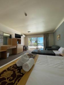 安特兰斯El Lago Waters Resort的酒店客房设有两张床和大窗户。