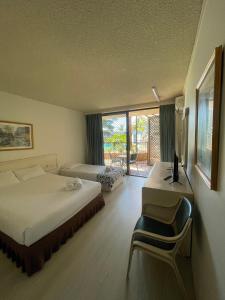 安特兰斯El Lago Waters Resort的一间卧室配有一张床和一张带电脑的书桌
