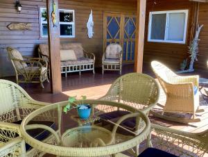 桑迪湾Reef Beach House - 2 Bedrooms and studio的露台设有藤椅和门廊上的桌子