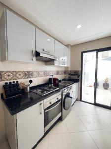 卡萨布兰卡High Standing & cozy apartment in central Casablanca的厨房配有白色橱柜和炉灶烤箱。