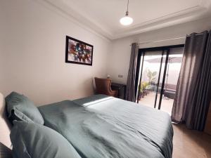 卡萨布兰卡High Standing & cozy apartment in central Casablanca的一间卧室设有一张床和一个滑动玻璃门
