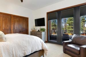 南太浩湖Ultimate Luxury Residence with Extras Galore across from Heavenly Village & Gondola - Zalanta Resort的一间卧室配有一张床、一把椅子和窗户。