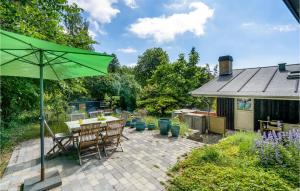 霍尔拜克Gorgeous Home In Holbk With Kitchen的一个带桌子和遮阳伞的庭院