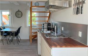 古兹耶姆Kbmandsgrden的厨房配有水槽、桌子和时钟