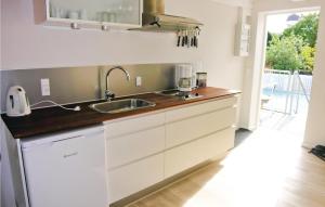 古兹耶姆Kbmandsgrden的厨房配有白色橱柜和水槽