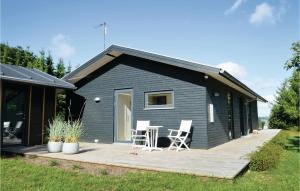 SkalsBeautiful Home In Skals With Wifi的黑色的小房子,配有甲板和两把椅子