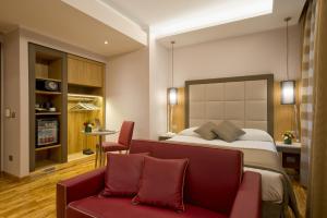 罗马Vibe Nazionale的酒店客房,配有一张床和一张红色的沙发