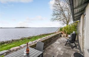 奥特鲁普Amazing Home In Otterup With House Sea View的一瓶葡萄酒坐在水边的桌子上