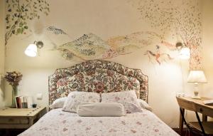 VillarrubiaCuevas del Pino Turismo Rural y Emocional SL的一间卧室配有一张带花卉图案墙壁的床