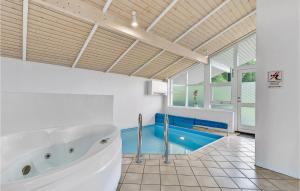 森讷比Beautiful Home In Juelsminde With Indoor Swimming Pool的带浴缸的浴室和游泳池