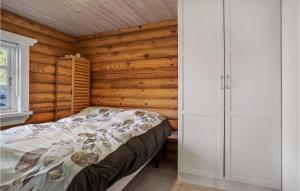 GørlevNice Home In Grlev With House Sea View的卧室配有一张床铺,位于带木墙的房间内