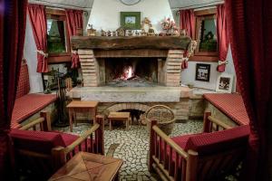维托里奥·威尼托Hotel Calvi-Ristorante Mainor的客厅设有壁炉和红色窗帘