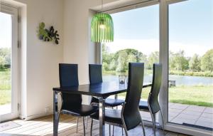 HeeBeautiful Home In Ringkbing With Wifi的餐桌、椅子和吊灯