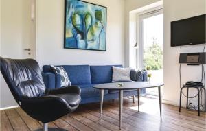 HeeBeautiful Home In Ringkbing With Wifi的客厅配有蓝色的沙发和桌子