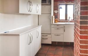 福堡Gorgeous Home In Faaborg With Sauna的厨房配有白色橱柜和砖墙