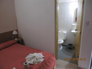 Villa Independencia桑蒂斯宾馆的一间卧室配有一张床,浴室设有卫生间