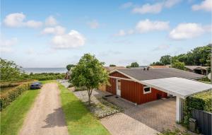 桑德比耶特Gorgeous Home In Bjert With Kitchen的一座红色的房子,设有太阳能屋顶和车道