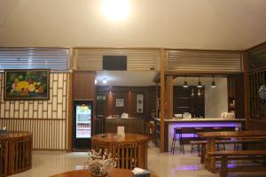 马贾伦卡Aluky Hotel的一间带木桌的用餐室和一间酒吧