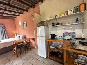 咖啡湾BlueCottage or Seaview Cottage at Coram Deo Lodge self catering的厨房配有冰箱、桌子和床。