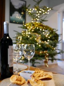 文盖尔斯卡－古尔卡Apartamenty Pod Hutą的桌子上摆放着一瓶葡萄酒和玻璃杯,上面有圣诞树