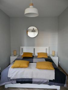 文盖尔斯卡－古尔卡Apartamenty Pod Hutą的一间卧室配有一张带黄色枕头和镜子的床