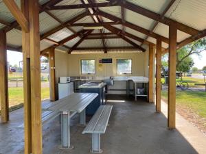 TemoraAirfield Tourist Park Temora的公园内带野餐桌和长凳的凉亭
