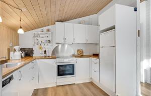 博利尔马克Cozy Home In Rm With Kitchen的白色的厨房配有白色家电和木制天花板