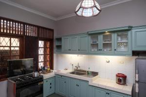 三宝垄SAREH VILLA by The Lavana的厨房配有蓝色橱柜、水槽和炉灶。