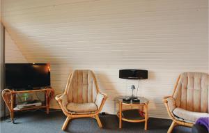 ÅrøPet Friendly Home In Haderslev With Wifi的配有电视的客房内的2把椅子和1张桌子