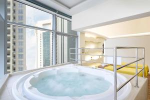 多哈Qabila Westbay Hotel by Marriott的带窗户的客房内的大浴缸
