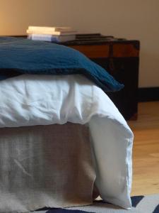 朗波普卢阿尔泽La vigie d'Héloïse, appartement de l'Aod的一张带白色床单和蓝色枕头的床