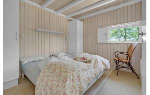 博托比伊德斯图普乌戈维杰4号度假屋的卧室配有床、椅子和窗户。
