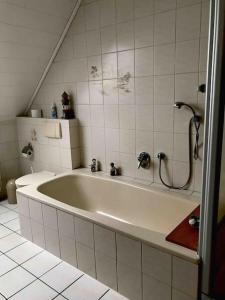 帕彭堡Haus Eierhof的浴室铺有白色瓷砖,配有浴缸。