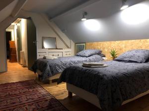 Épreville-en-RoumoisGite, l'Epicerie d'Epreville的一间卧室配有两张带蓝色棉被的床