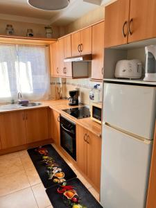 帕莱索海滩Casa Jerome的厨房配有木制橱柜和白色冰箱。