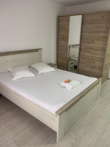 拉姆尼库沃尔恰Cazare bloc nou ultracentral的卧室配有一张带镜子的白色大床