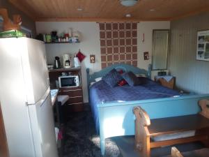 萨翁林纳Rantakallio Savonlinna, Tervetuloa meille!的一间卧室配有蓝色的床和冰箱
