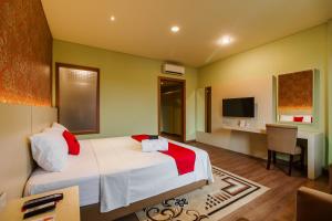 雅加达RedDoorz Plus near Dunia Fantasi Ancol的一间卧室配有一张床、一张书桌和一台电视