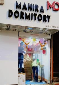 孟买Mahira Dormitory的站在商店橱窗里的男人和女人
