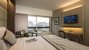 库尔布瓦库尔布瓦拉德芳斯公寓式酒店的配有一张床、一张书桌和一扇窗户的酒店客房